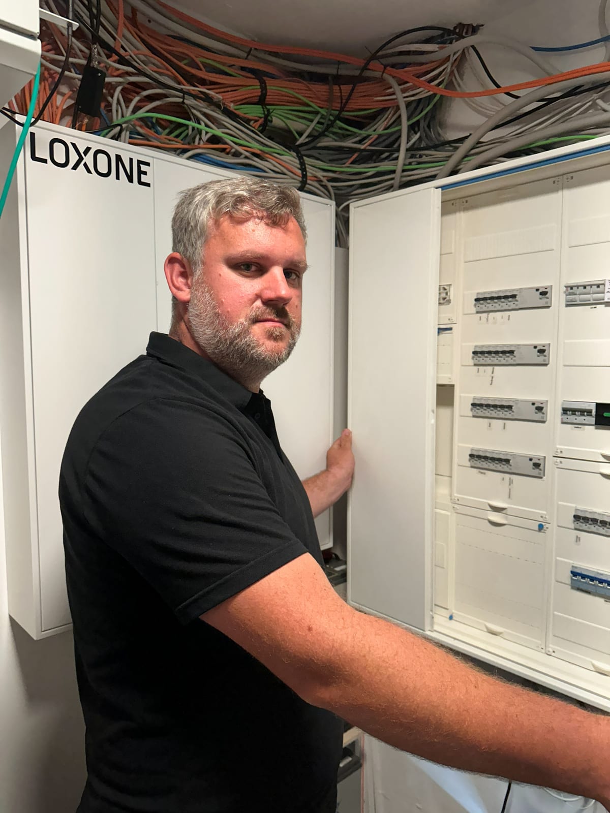 Bastian Storp im Technikraum vor dem geöffneten Schaltschrank