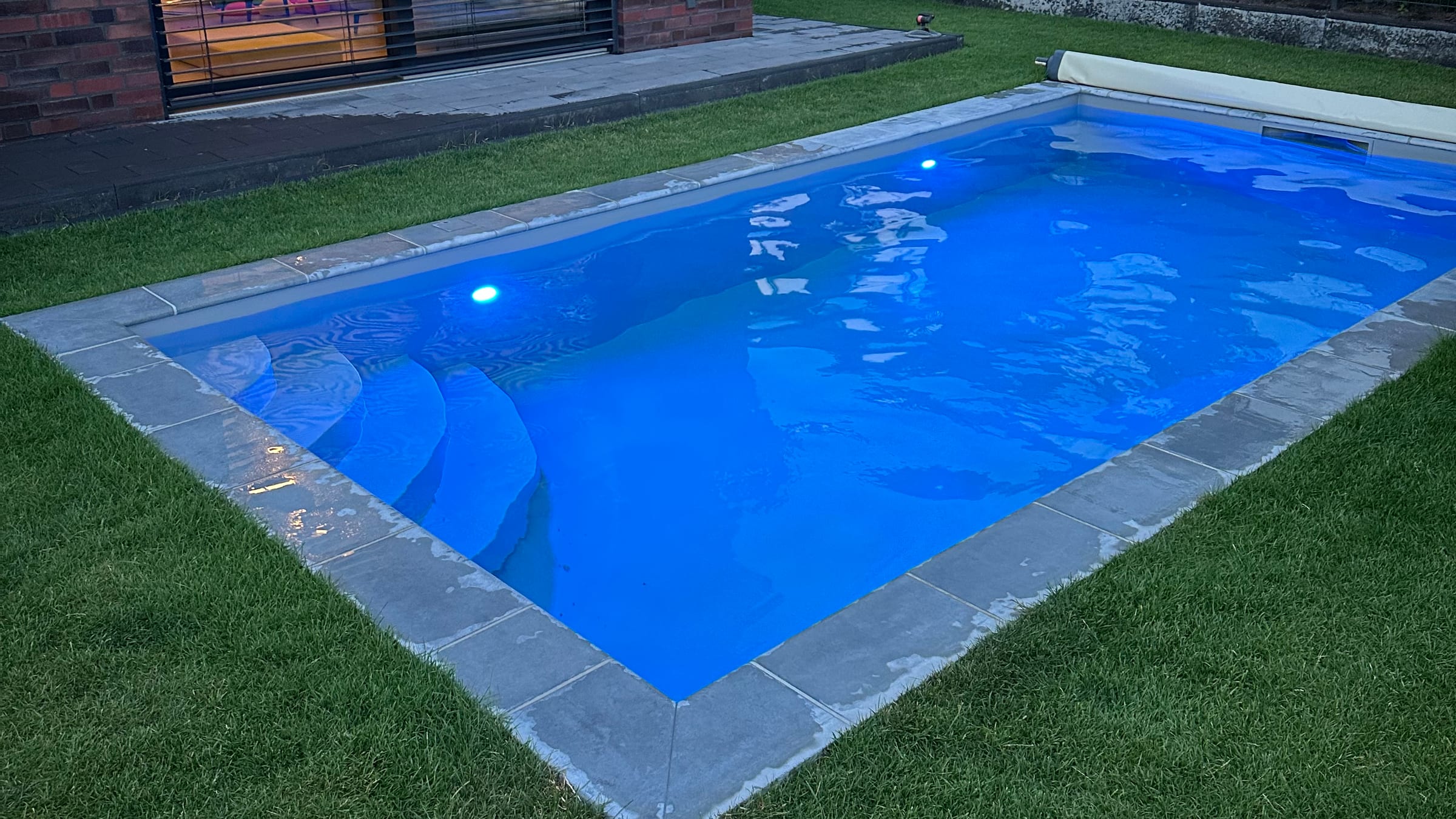 Unser eigener Pool am Abend mit farbiger LED-Beleuchtung